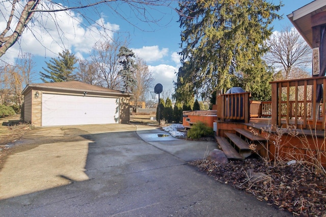 exterior space with a wooden deck, a detached garage, and an outdoor structure