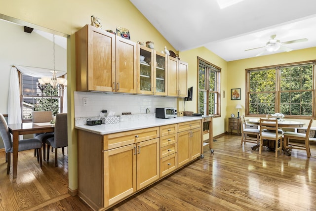 kitchen with dark wood-style floors, vaulted ceiling, and tasteful backsplash