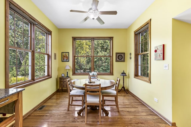 dining area with a ceiling fan, visible vents, baseboards, and wood finished floors