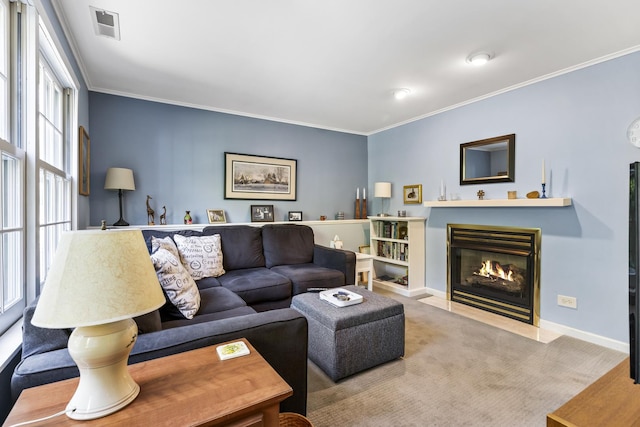 carpeted living room featuring a fireplace with flush hearth, visible vents, baseboards, and ornamental molding