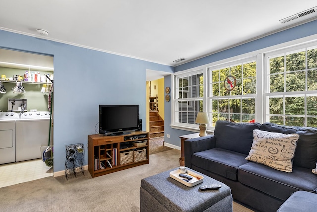 carpeted living area featuring plenty of natural light, visible vents, and washing machine and clothes dryer