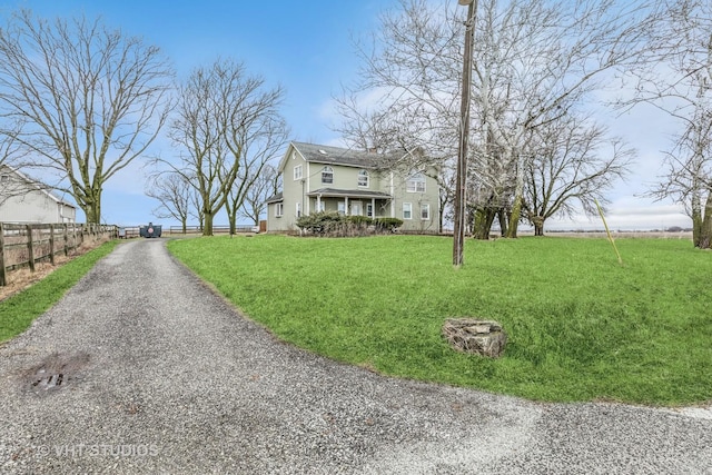 exterior space with driveway, fence, and a front lawn