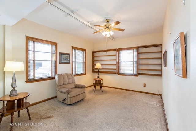 sitting room featuring baseboards, carpet, and a healthy amount of sunlight