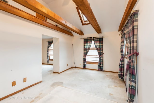 empty room with lofted ceiling with skylight and baseboards