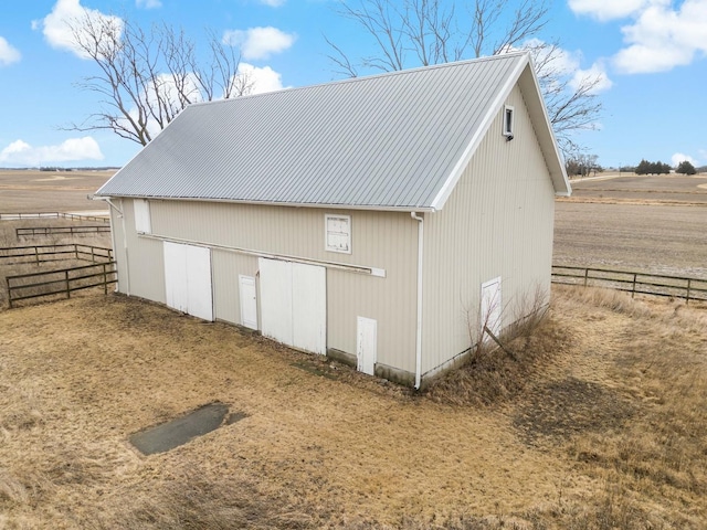 exterior space with a rural view, fence, and an outbuilding