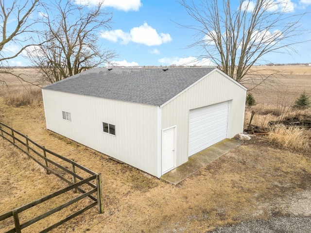 exterior space with an outbuilding, a shingled roof, fence, a garage, and driveway