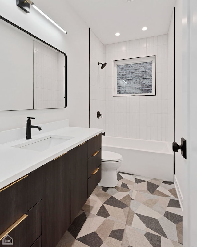 full bathroom featuring tiled shower / bath combo, vanity, and toilet