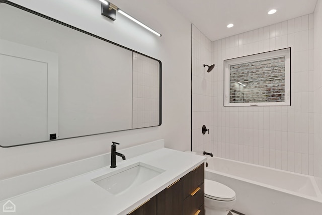 full bathroom featuring tiled shower / bath combo, toilet, and vanity