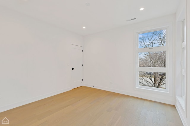 spare room with a wealth of natural light and light hardwood / wood-style flooring