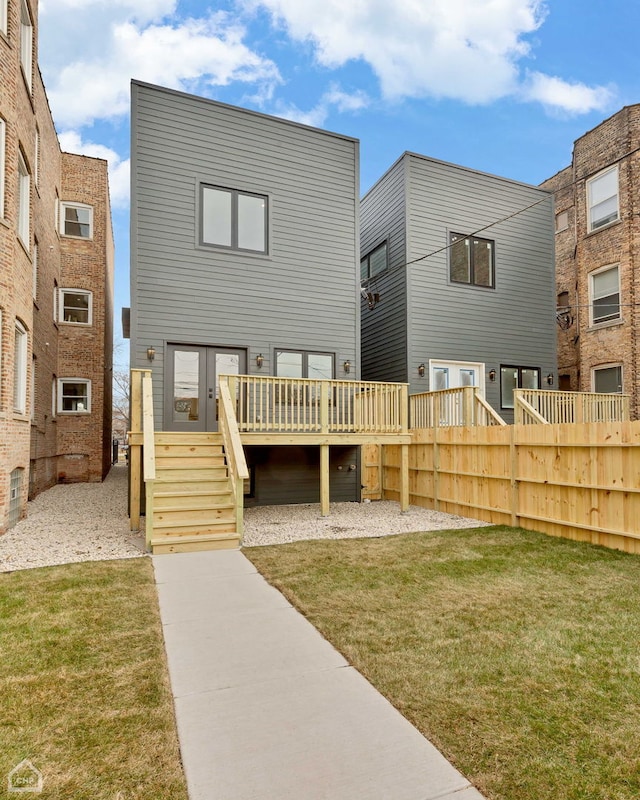 rear view of house featuring a yard and a deck