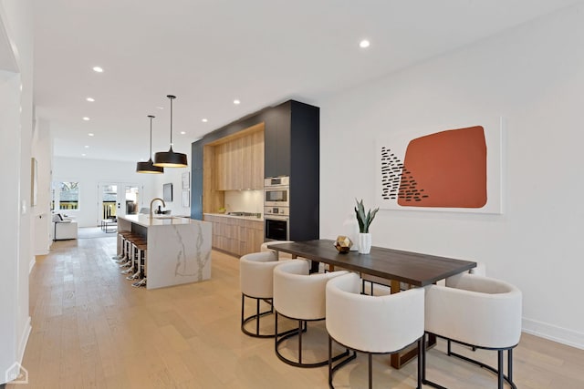 dining area with sink and light hardwood / wood-style flooring