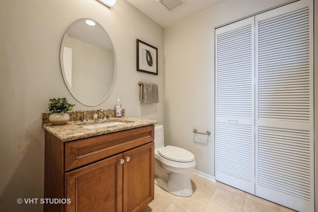 bathroom featuring a closet, visible vents, toilet, vanity, and tile patterned floors