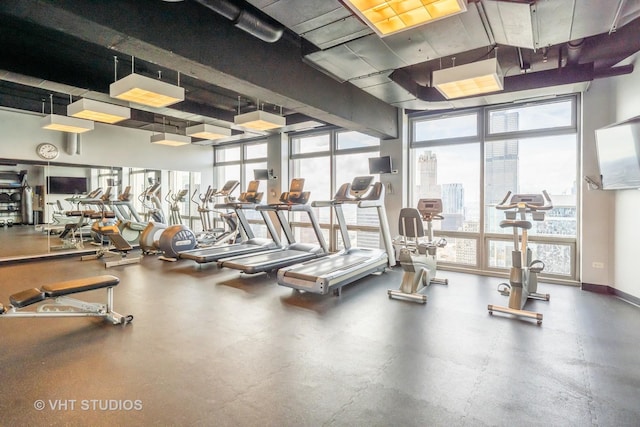 gym with plenty of natural light, expansive windows, and baseboards