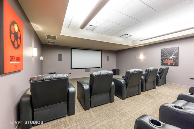 cinema featuring baseboards, a tray ceiling, visible vents, and light colored carpet