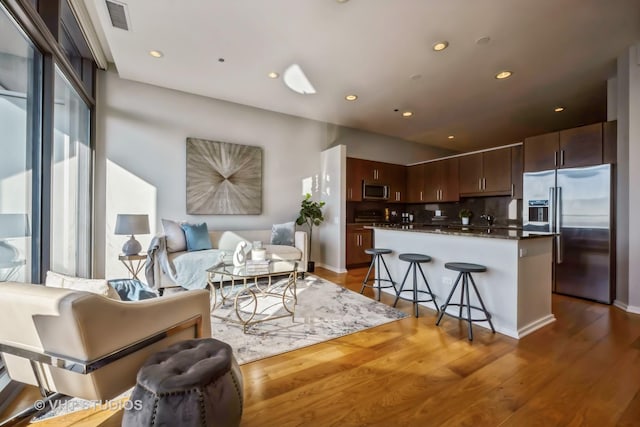 living area featuring visible vents, wood finished floors, and recessed lighting