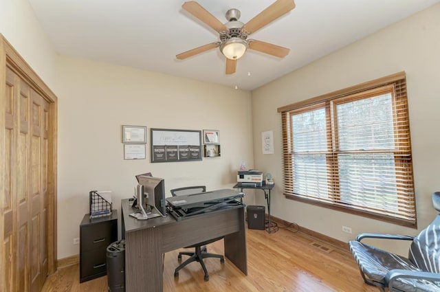 office area with a ceiling fan, light wood-style flooring, and baseboards