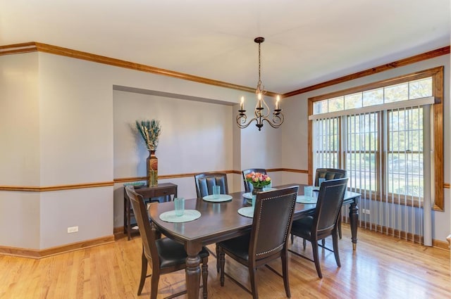 dining room featuring crown molding, baseboards, an inviting chandelier, and light wood-style floors