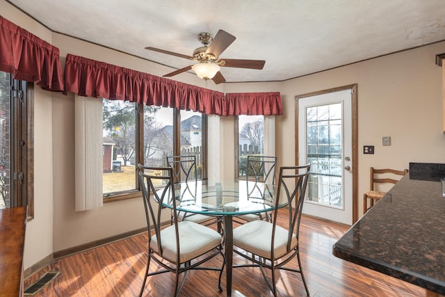 dining room with a wealth of natural light, visible vents, baseboards, and wood finished floors