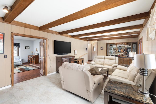 living room with beamed ceiling and wooden walls