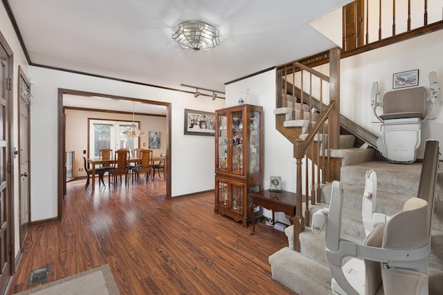 interior space featuring wood finished floors, visible vents, baseboards, stairs, and crown molding