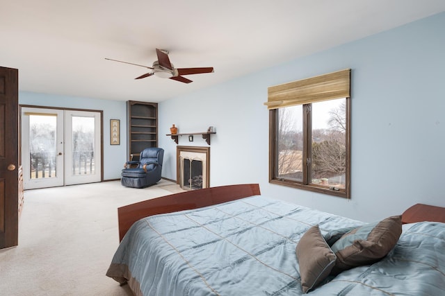 bedroom featuring access to exterior, multiple windows, a fireplace, and carpet