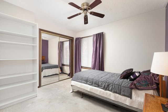 bedroom featuring a closet, a textured ceiling, carpet flooring, and a ceiling fan