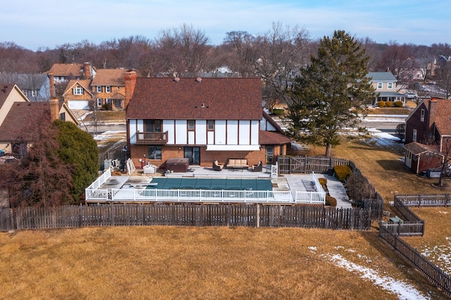 rear view of house with a fenced in pool, a lawn, a fenced backyard, a balcony, and a patio