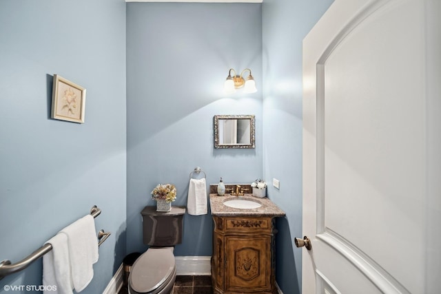 bathroom with toilet, tile patterned flooring, vanity, and baseboards