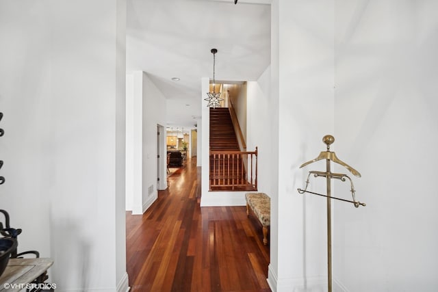 hall featuring dark wood-style flooring, baseboards, and stairs