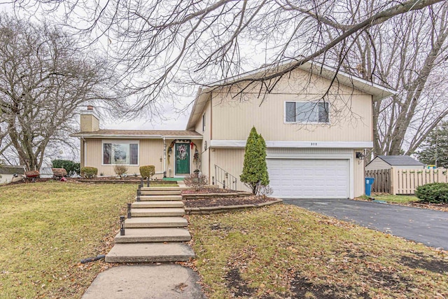 tri-level home featuring a front lawn and a garage