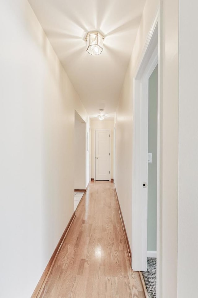 hallway with light wood-style flooring and baseboards