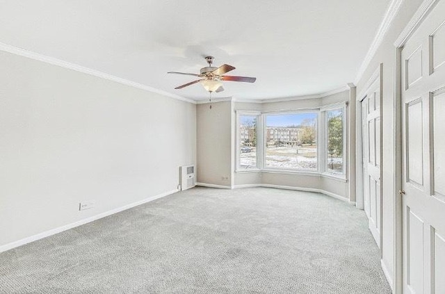 unfurnished room with light carpet, ornamental molding, a ceiling fan, and baseboards