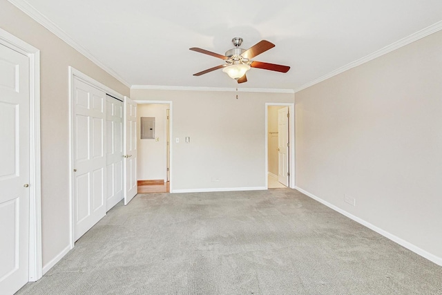 unfurnished bedroom with electric panel, baseboards, carpet, crown molding, and a closet