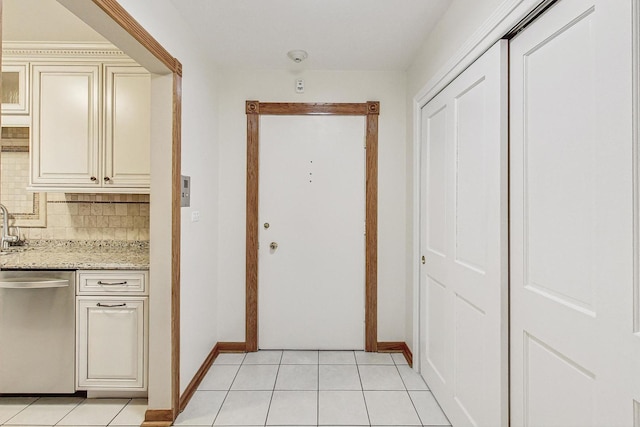 corridor featuring light tile patterned floors and baseboards