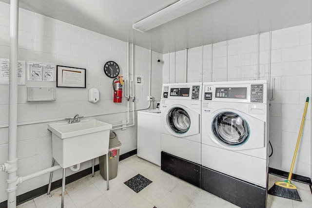 community laundry room with washing machine and dryer and a sink