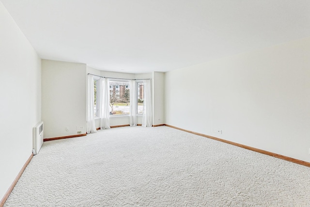 carpeted spare room with baseboards