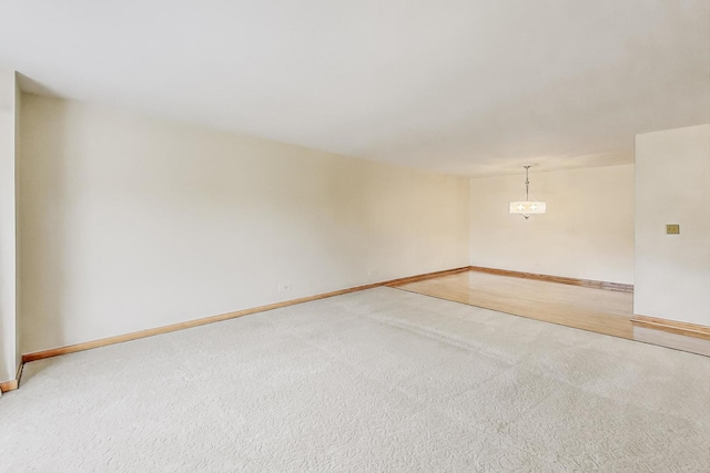 unfurnished room with light carpet and baseboards