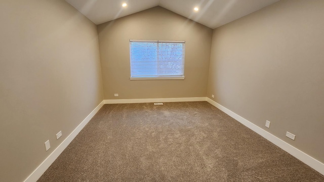 carpeted empty room with lofted ceiling