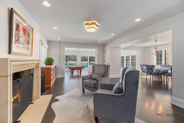 living area featuring a chandelier, dark wood-style floors, billiards, and a premium fireplace