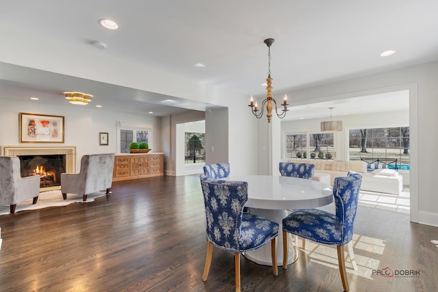 dining area featuring recessed lighting, a healthy amount of sunlight, a fireplace, and dark wood-style flooring