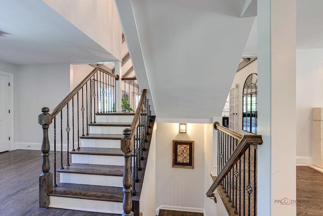 staircase with baseboards and wood finished floors