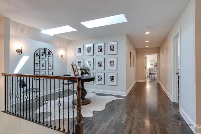 corridor with visible vents, wood finished floors, recessed lighting, a skylight, and baseboards