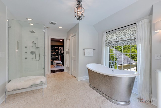 bathroom with a freestanding tub, a walk in closet, visible vents, a stall shower, and recessed lighting