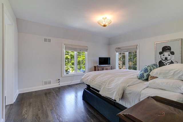 bedroom with visible vents, multiple windows, and wood finished floors