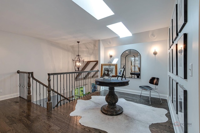 interior space with an upstairs landing, wood finished floors, baseboards, and a chandelier