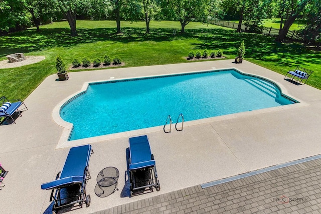 view of swimming pool with fence, a yard, a fire pit, a fenced in pool, and a patio area