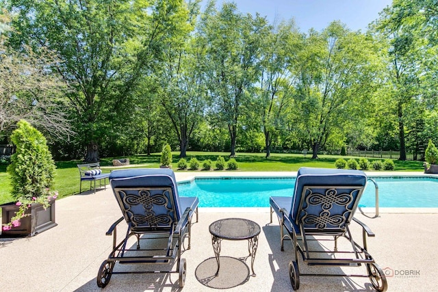 pool featuring a lawn and a patio