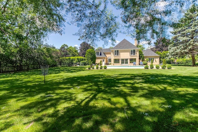 back of house with a patio, a yard, an outdoor pool, and a chimney