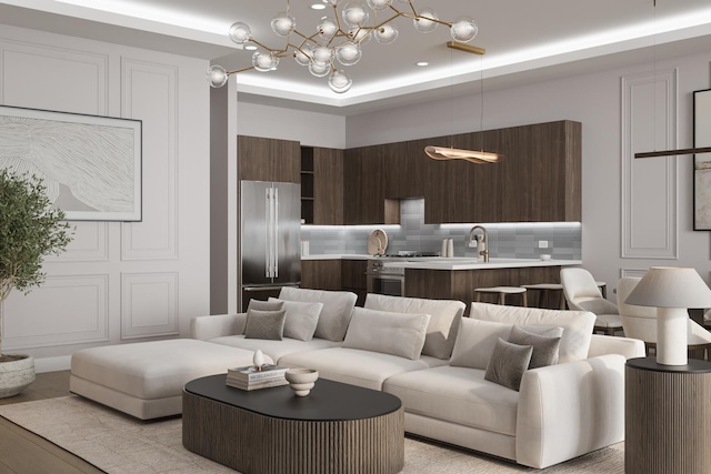 living room featuring a tray ceiling and sink