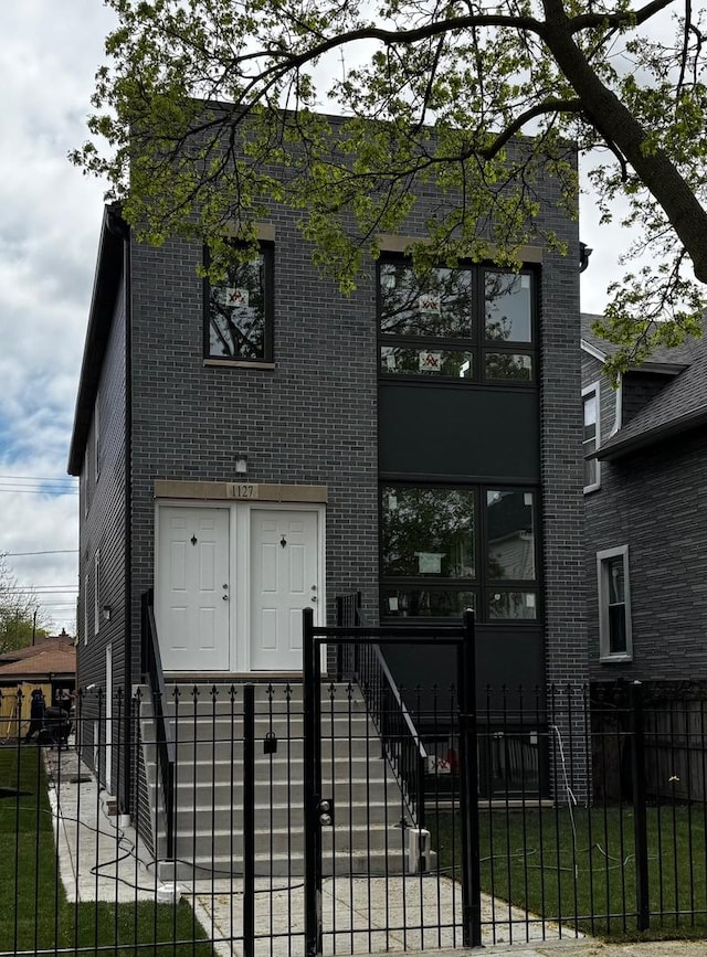 view of front of property with brick siding and a fenced front yard